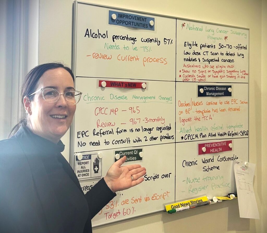 GP practice manager showing board of quality improvement activities to help boost take-up of eScripts.